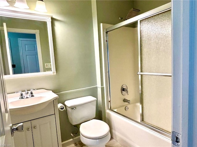 bathroom with vanity, toilet, and combined bath / shower with glass door