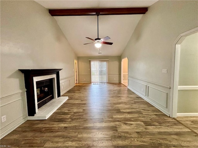 unfurnished living room featuring a fireplace with raised hearth, a ceiling fan, wood finished floors, arched walkways, and a decorative wall