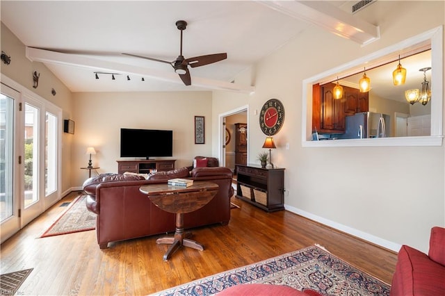 living room featuring beamed ceiling, wood finished floors, visible vents, and baseboards