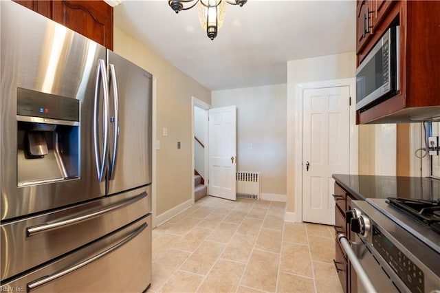 kitchen featuring radiator heating unit, light tile patterned flooring, baseboards, and appliances with stainless steel finishes