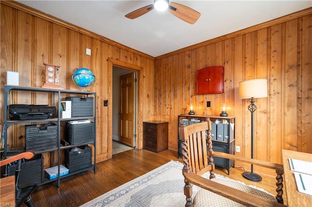 home office featuring ceiling fan, wooden walls, wood finished floors, and ornamental molding