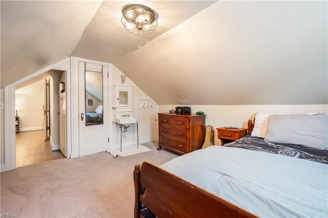 bedroom featuring light carpet and vaulted ceiling