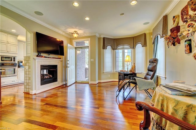 entryway with baseboards, light wood finished floors, recessed lighting, ornamental molding, and a glass covered fireplace