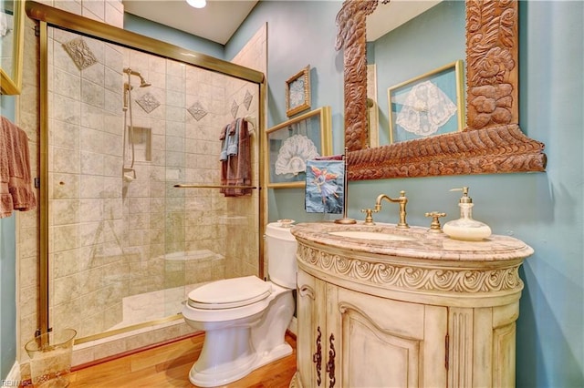 bathroom featuring a stall shower, toilet, and vanity