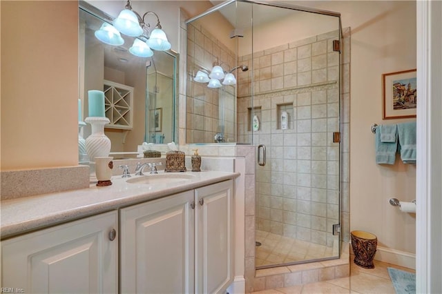 full bath with tile patterned floors, vanity, a chandelier, and a shower stall