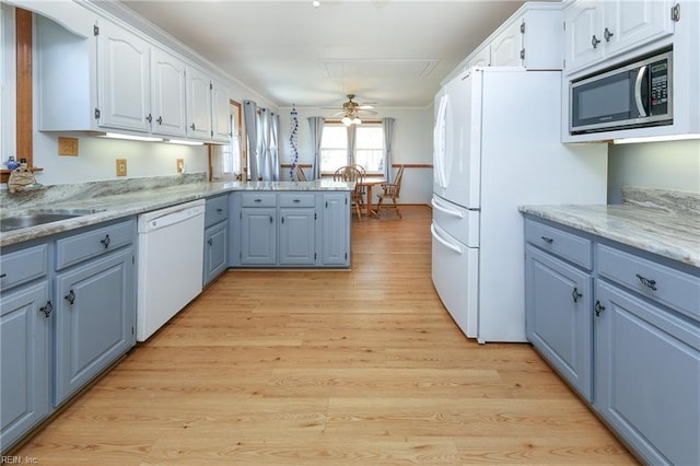 kitchen featuring light wood-type flooring, a peninsula, white cabinets, white appliances, and blue cabinets