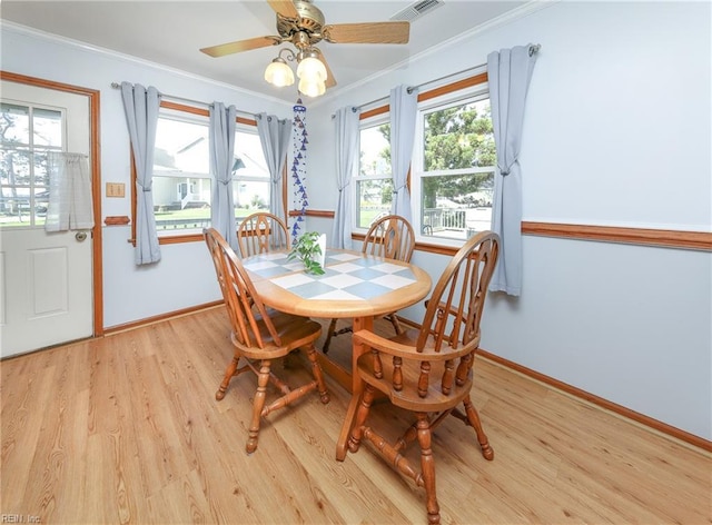 dining area featuring crown molding, baseboards, light wood-type flooring, and visible vents