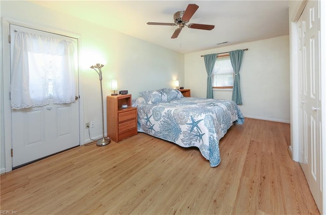 bedroom featuring visible vents, baseboards, light wood-type flooring, and ceiling fan