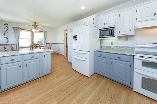 kitchen with light wood-style flooring, a ceiling fan, under cabinet range hood, white appliances, and white cabinets