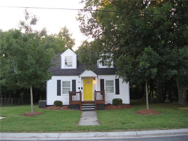 cape cod-style house with cooling unit and a front lawn