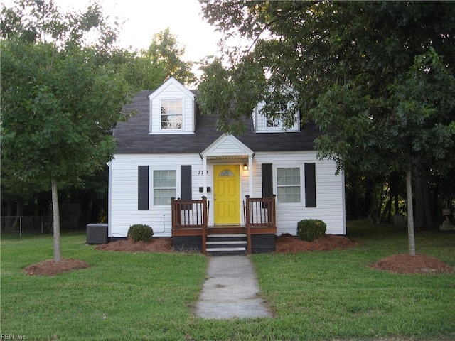 cape cod home with a front lawn and central AC unit