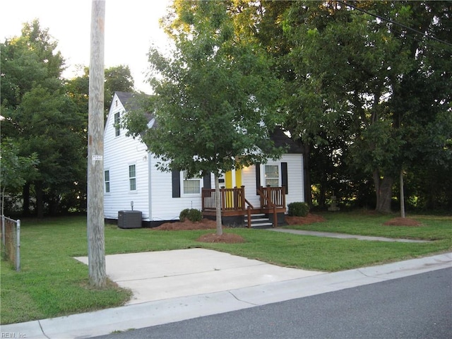 obstructed view of property featuring a front lawn and cooling unit