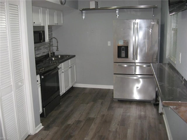 kitchen with tasteful backsplash, stainless steel appliances, dark wood-style floors, white cabinetry, and a sink