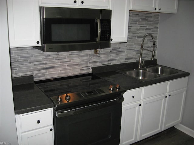 kitchen with dark countertops, electric range, tasteful backsplash, and a sink