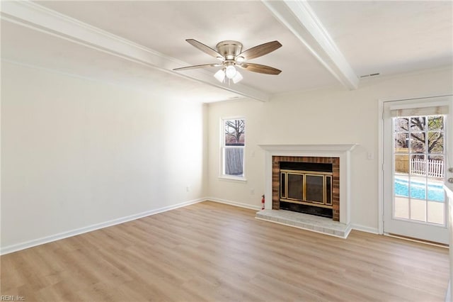 unfurnished living room with beamed ceiling, light wood-style flooring, a brick fireplace, and baseboards