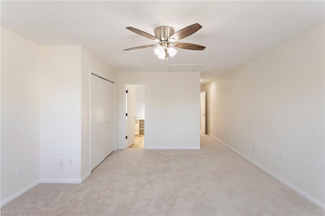 unfurnished room with attic access, a ceiling fan, baseboards, and light carpet