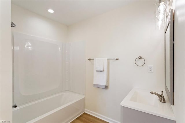 full bathroom featuring vanity, wood finished floors, baseboards, recessed lighting, and shower / bathing tub combination