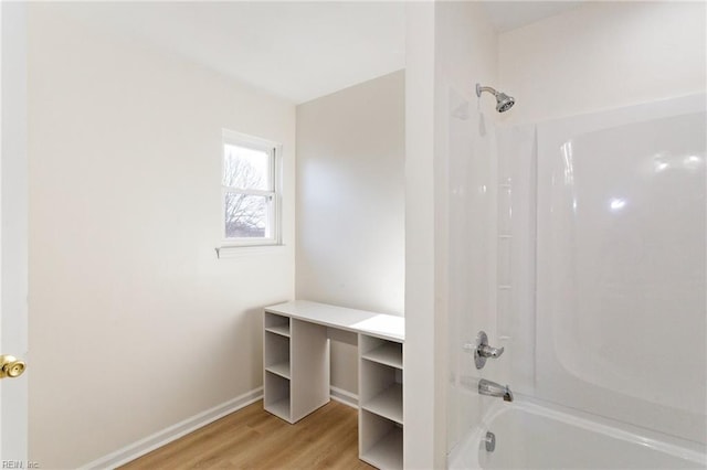 full bathroom with shower / tub combination, baseboards, and wood finished floors