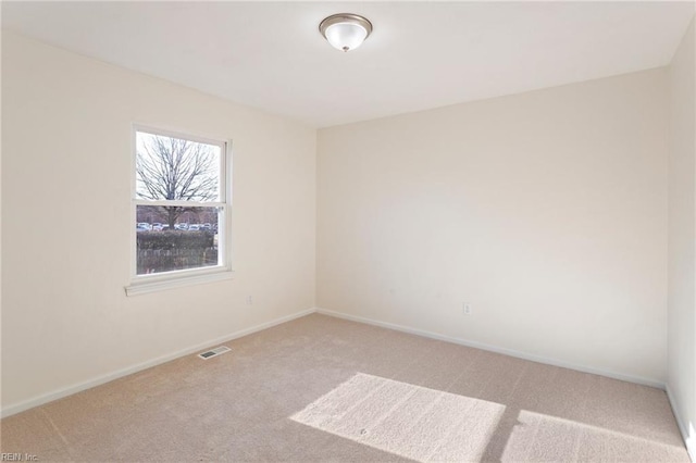 empty room featuring visible vents, baseboards, and carpet flooring