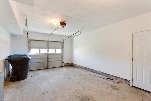 garage featuring a garage door opener and baseboards