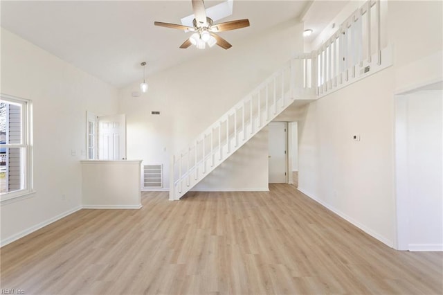 unfurnished living room with stairs, baseboards, visible vents, and high vaulted ceiling