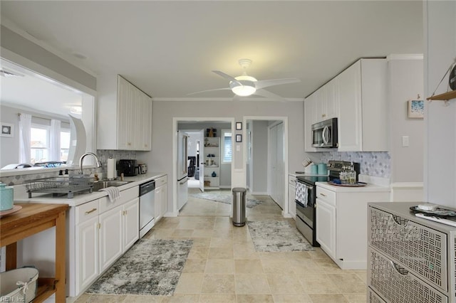 kitchen with backsplash, appliances with stainless steel finishes, light countertops, and ceiling fan