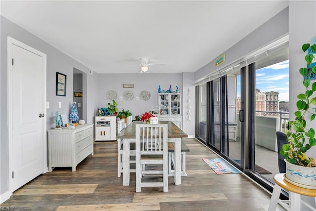 dining space with a ceiling fan and wood finished floors