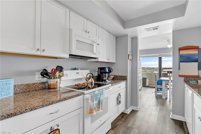 kitchen with white appliances, visible vents, stone counters, dark wood-type flooring, and white cabinets