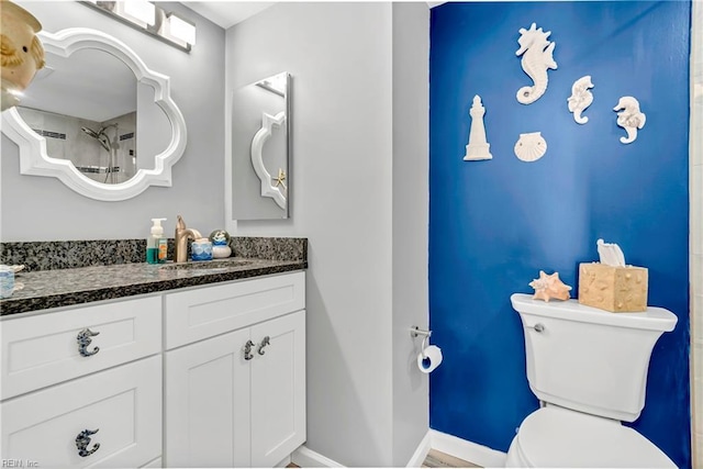 bathroom featuring vanity, toilet, and baseboards