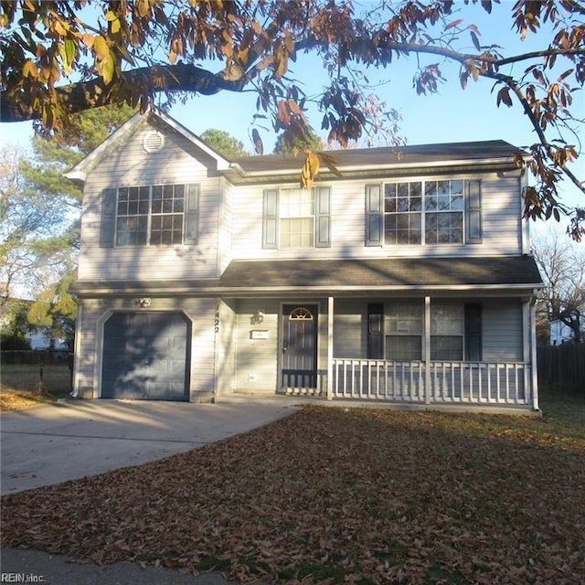 traditional-style house featuring an attached garage, covered porch, and driveway