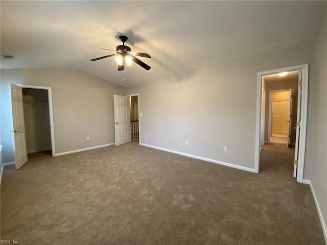 unfurnished bedroom featuring dark colored carpet, baseboards, ceiling fan, and vaulted ceiling