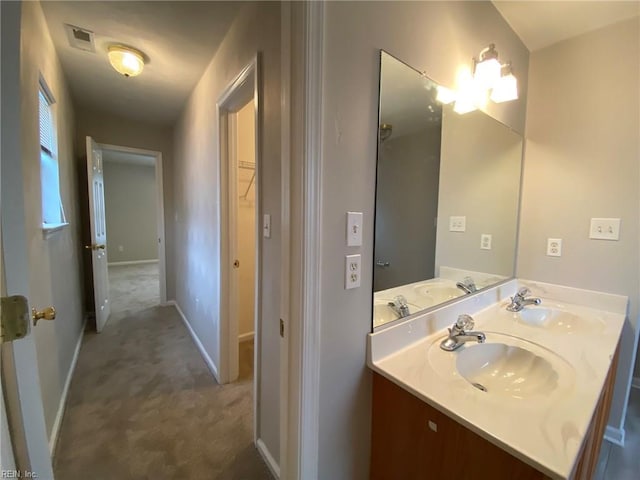 bathroom featuring visible vents, baseboards, and a sink