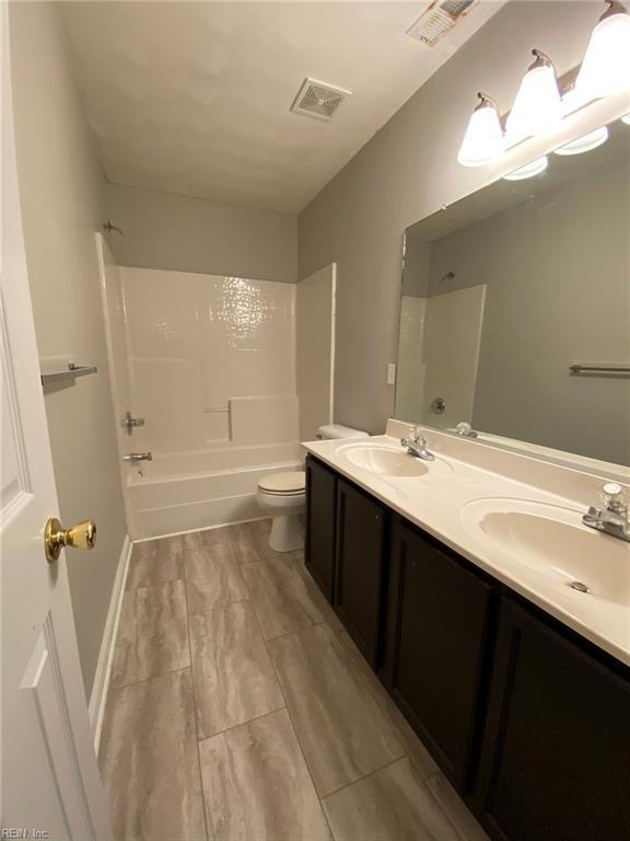 bathroom featuring toilet, visible vents, and a sink