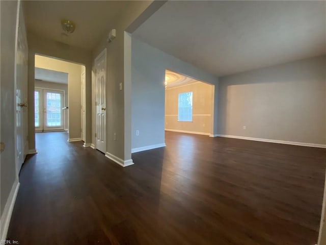 unfurnished room featuring baseboards and dark wood finished floors