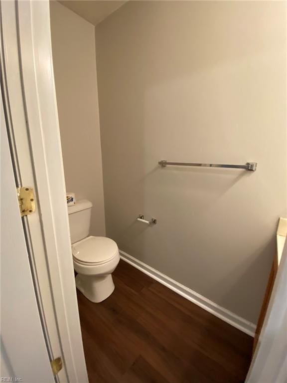 bathroom featuring toilet, baseboards, and wood finished floors