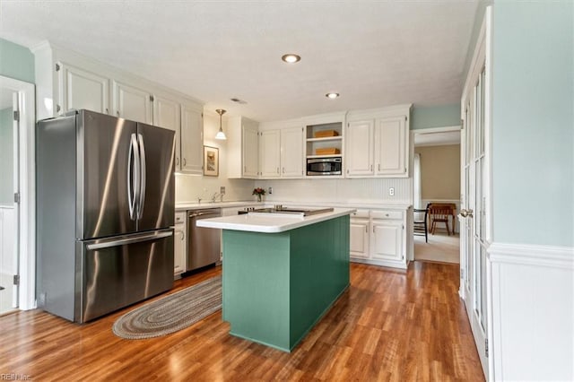 kitchen with a wainscoted wall, open shelves, appliances with stainless steel finishes, white cabinets, and light countertops