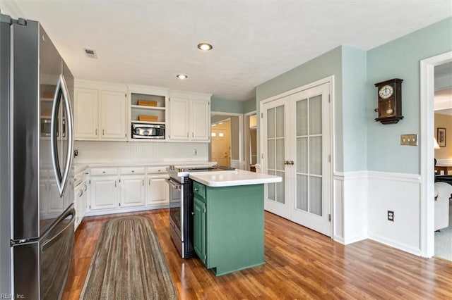 kitchen featuring open shelves, french doors, appliances with stainless steel finishes, green cabinets, and light countertops