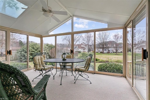 sunroom / solarium with lofted ceiling with skylight, a healthy amount of sunlight, and ceiling fan