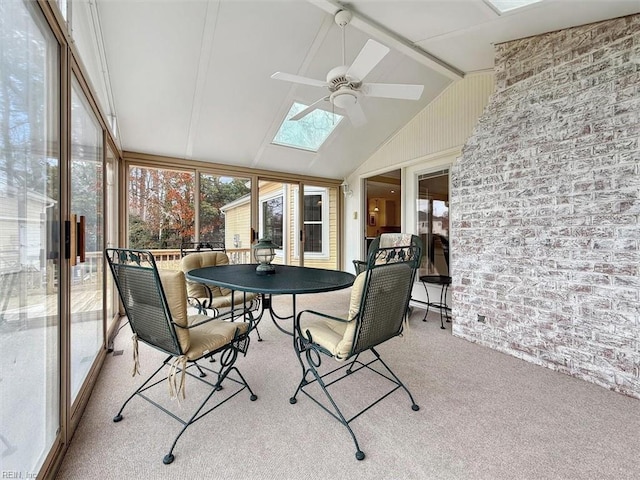 sunroom / solarium with lofted ceiling with skylight, plenty of natural light, and a ceiling fan