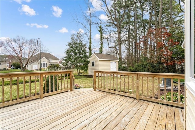 wooden deck featuring an outbuilding and a yard