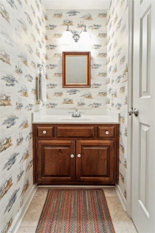 bathroom featuring tile patterned floors, wallpapered walls, vanity, and baseboards