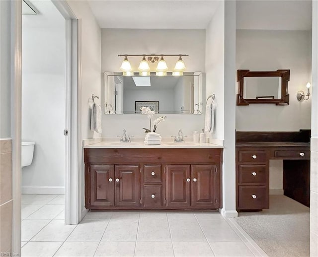 full bath featuring double vanity, tile patterned floors, baseboards, and a sink