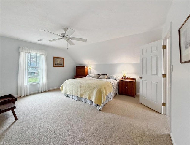 bedroom featuring baseboards, light carpet, and vaulted ceiling