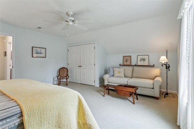 bedroom featuring a ceiling fan, visible vents, lofted ceiling, a closet, and light carpet