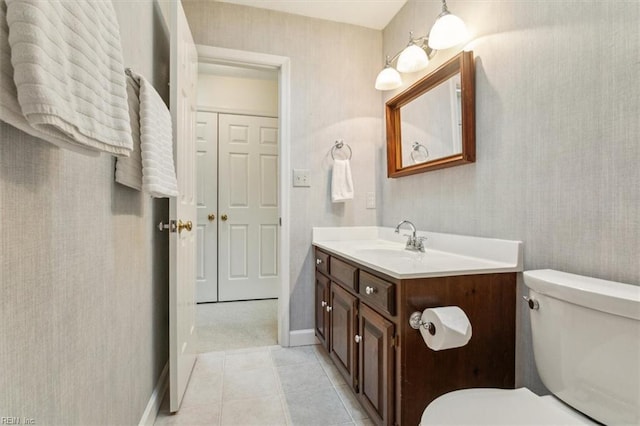 bathroom featuring vanity, toilet, tile patterned flooring, and wallpapered walls