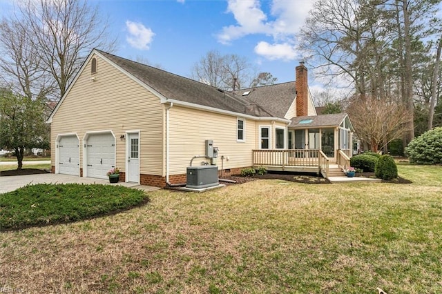 rear view of property with a wooden deck, cooling unit, a chimney, a garage, and driveway