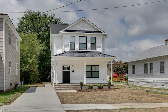 modern farmhouse style home with metal roof, covered porch, and a standing seam roof