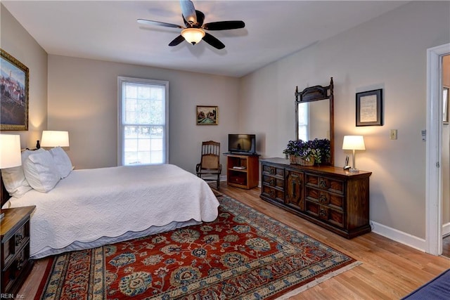 bedroom with baseboards, wood finished floors, and a ceiling fan