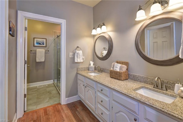 bathroom featuring a sink, a stall shower, and wood finished floors