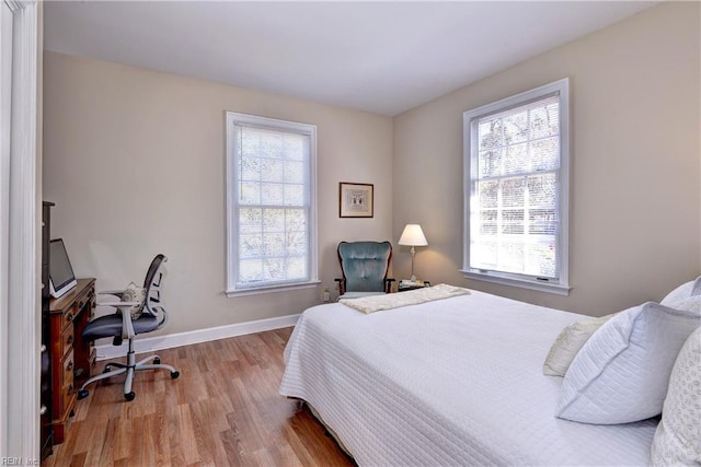 bedroom with baseboards and wood finished floors